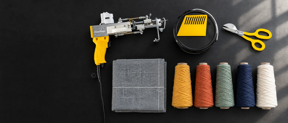 Knolling van tufting benodigdheden op een donkere ondergrond: tufting gun, lijm, schaar, doek en wol