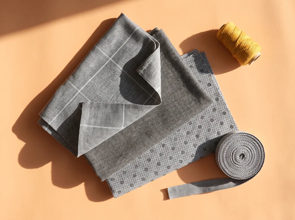 Grijs primair tufting doek met witte hulplijnen, uitgewaaierd met secundair doek, anti-slip doek en bindingstape